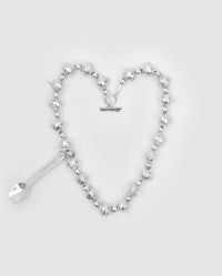 a silver heart shaped bracelet with a spoon on it